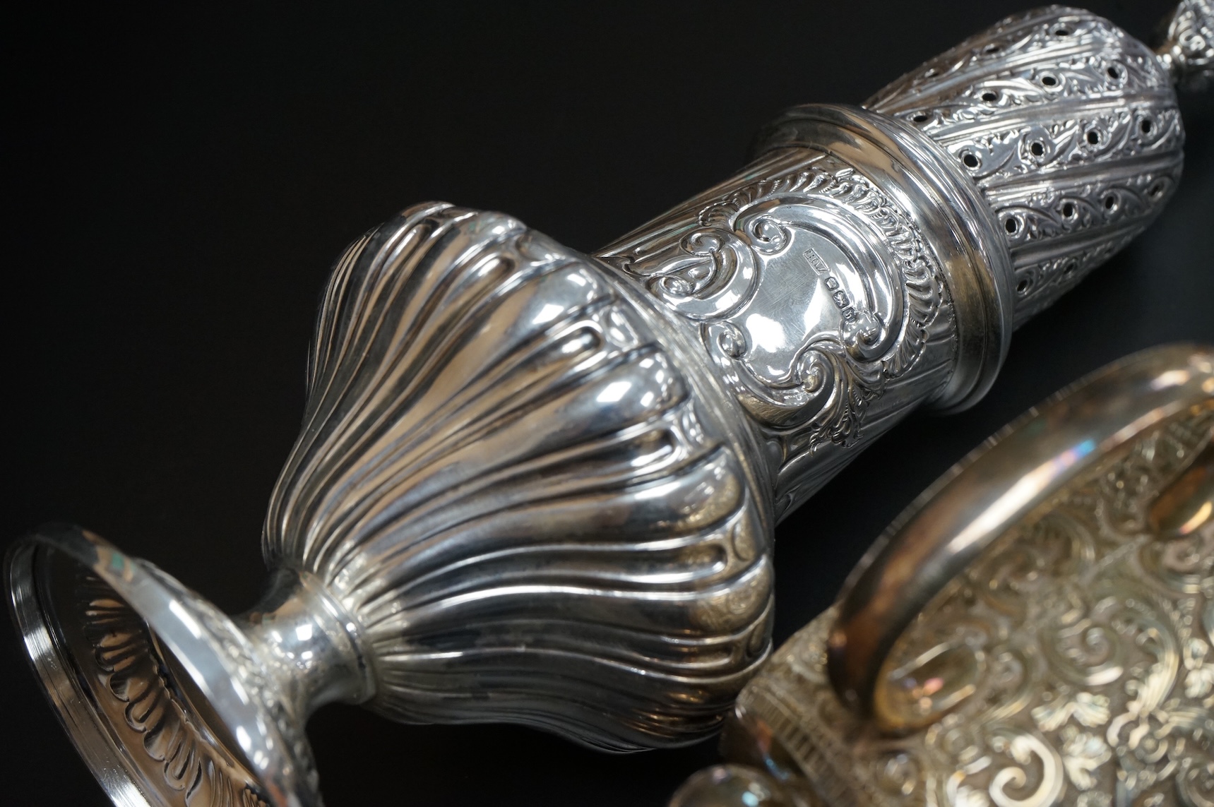 A Victorian embossed silver christening mug, on three ball feet, Martin, Hall & Co, London, 1874, height 85mm, together with a similar sugar caster, Lee & Wigful, Sheffield, 1899.